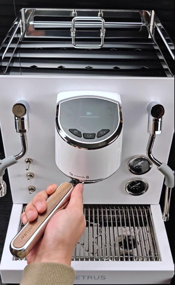 Barista holding the Airflow flat mirror portafilter in front of a white espresso machine
