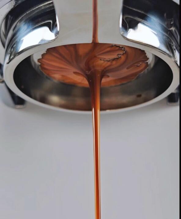 Espresso extracting evenly from a bottomless portafilter into one central stream