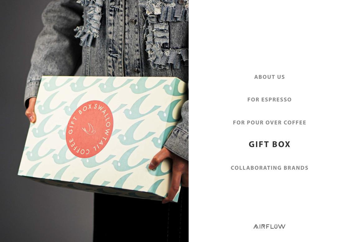 A patterned Airflow Swallowtail Coffee gift box held by someone in a denim jacket.